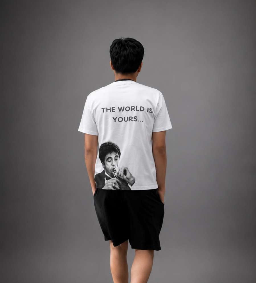 Vit T-shirt med texten "The World Is Yours" från RISKTAKERS, nära visning av trycket och passformen.